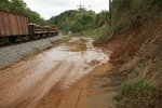 Ballast hopper cars and side-dump cars pass a recent mudslide on Hydro St. brought on by recent heavy rains